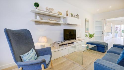 拉奥利瓦Casa MIMAR - moderna, jardín y wifi fibra 1 GB, ideal para vacaciones y teletrabajo的客厅配有2把蓝色椅子和电视