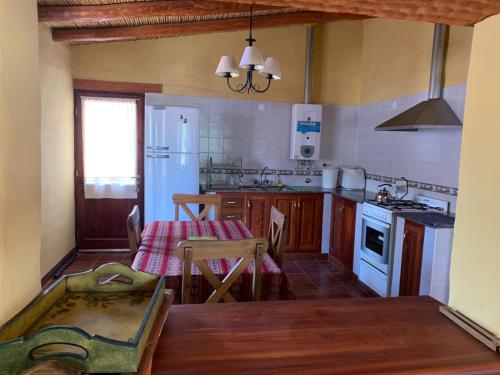 蒂尔卡拉La casa de Mamina的一间带桌子的厨房和一间带炉灶的厨房