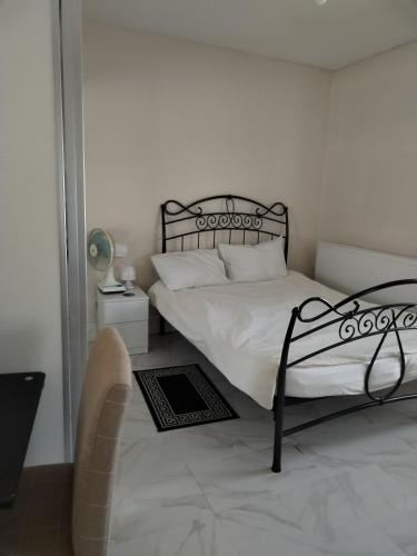 布雷得佛Balfour Street的一间卧室配有一张带白色床单和椅子的床