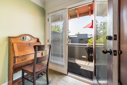 西雅图Seattle Gaslight Inn的客房设有木制书桌和窗户。
