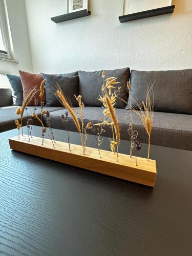 盖尔森基兴Modernes Apartment in Stadionnähe的木桌边的沙发上摆放着一些植物