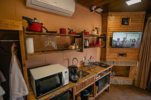 乌鲁比西Sunset Serrano Chalés的带微波炉的厨房和台面电视