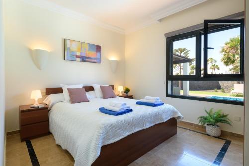 普拉亚布兰卡Hipoclub Villas, "Rosa" villa的一间卧室配有一张床,上面有两条毛巾