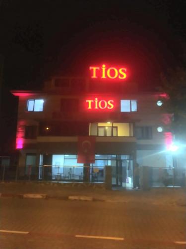 宗古尔达克TİOS OTEL的夜间在建筑物前的图标