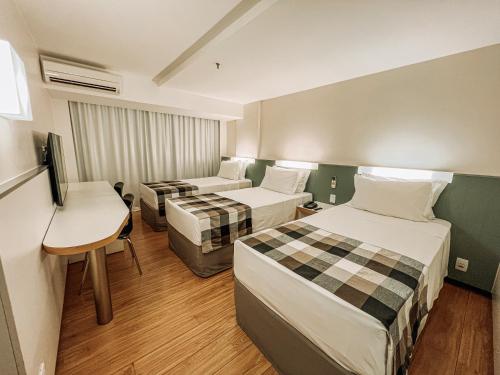 巴西利亚圣保罗广场酒店 的酒店客房配有两张床和一张书桌