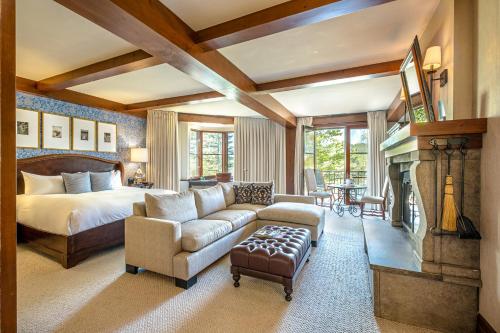 蒙特朗布朗第五元素酒店的一间卧室配有一张床、一张沙发和一个壁炉