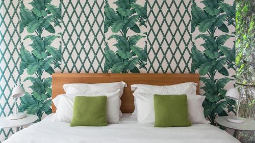 布宜诺斯艾利斯家园酒店的一张带白色床单和绿色枕头的床