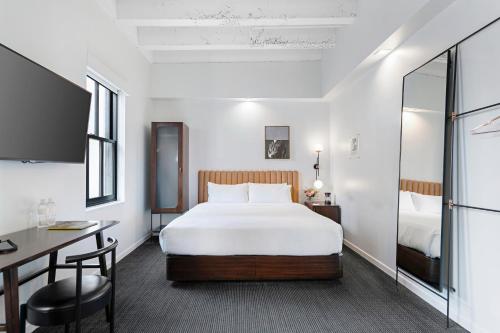 圣地亚哥The Guild Hotel, a Marriott Tribute Portfolio Hotel的配有一张床和一张书桌的酒店客房