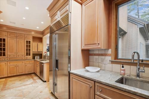 斯托Stowe Haven的厨房配有木制橱柜和不锈钢冰箱。