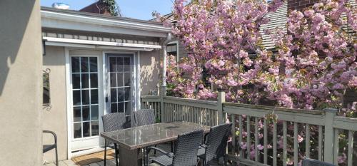 科尔本港运河畔餐厅厨房商店公寓的庭院设有带桌椅的鲜花围栏。