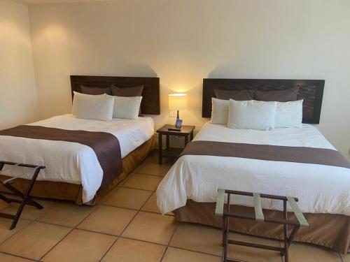 普拉亚科罗纳多Private Owned Suite at Coronado Luxury Suite Hotel & Golf Course的酒店客房设有两张床和一张桌子。
