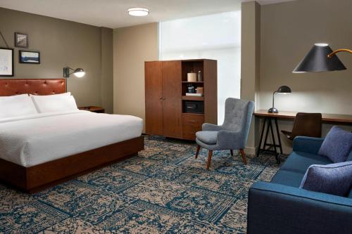 米西索加Four Points by Sheraton Toronto Airport的酒店客房配有一张床、一张桌子和一把椅子。