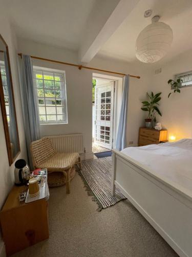 伦敦维多利亚中央公寓的一间卧室配有一张床、一把椅子和窗户。