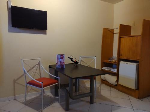 圣若泽Motel Kalipso的配有桌子、椅子和电视的房间
