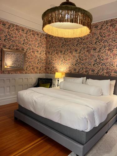帕罗奥多Cowper Inn的一间卧室配有一张大床和一个吊灯。
