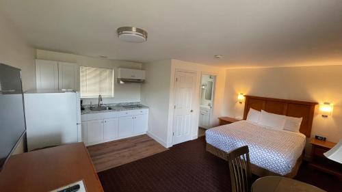 Milton-FreewaterMorgan Inn and Suites Walla Walla的一间卧室配有一张床,厨房配有冰箱