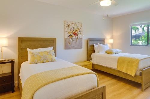 珊瑚角Pet-Friendly Cape Coral Vacation Rental with Lanai!的一间卧室设有两张床和一张带台灯的桌子。