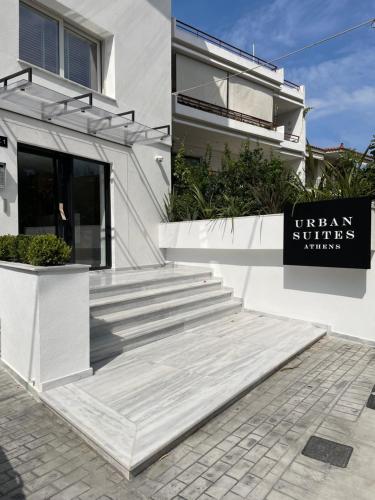 雅典URBAN SUITES ATHENS的伊塔尼一室公寓前有标志的白色建筑