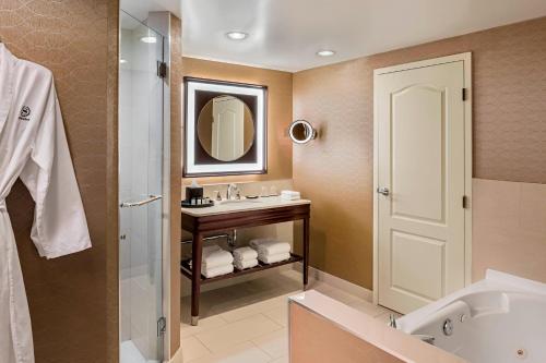 卡尔加里卡尔加里奥克莱尔喜来登套房酒店的一间带水槽、浴缸和镜子的浴室
