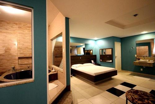 圣若泽Motel Kalipso的一间卧室配有一张床,浴室设有浴缸