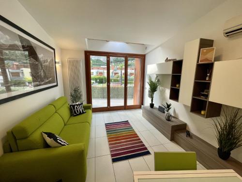 托尔博莱Outdooredo Garda Torbole的客厅设有绿色沙发和窗户。