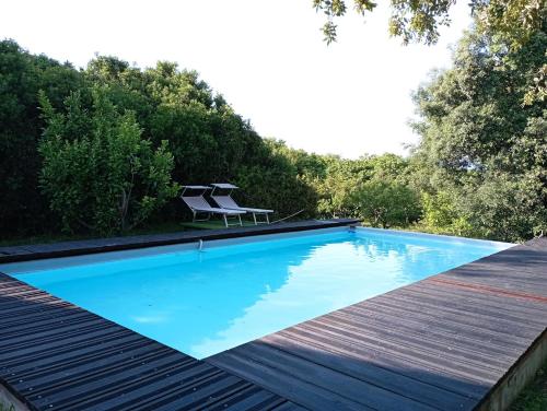 普佐伊杜Sardinia Ovest 2的一个带两把椅子的游泳池,位于木甲板上
