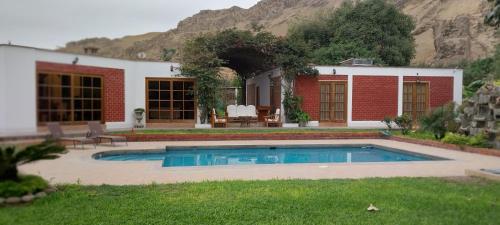 帕查卡马克Las buganvilias的庭院中带游泳池的房子
