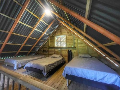 El PeñolEspectacular Cabaña Loft en Guatape - Jacuzzi的阁楼间设有两张床,设有屋顶