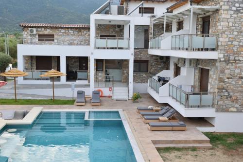 克里斯阿穆迪亚Dioscuri Deluxe Apartments的一座别墅,在一座建筑前设有一个游泳池
