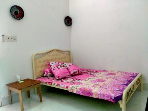 槟知Room in Vietnam 1的一张带粉红色枕头的床和一张桌子