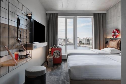 卑尔根Moxy Bergen的酒店客房设有两张床和电视。