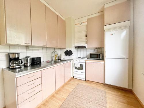 图尔库Woodpecker Avenue Family Apartment Turku的厨房配有白色橱柜和白色冰箱。