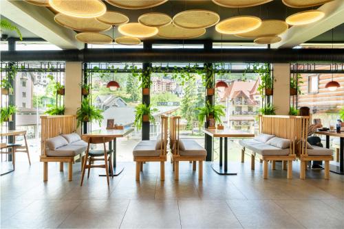 布克维Bukville Hotel & SPA的餐厅设有桌椅和大窗户。