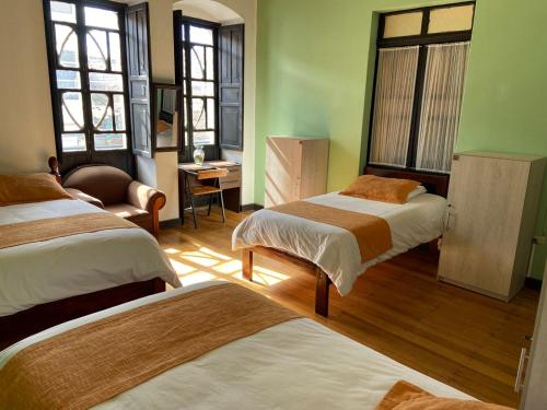 里奥班巴Villa Bonita Hostel的客房设有两张床、椅子和窗户。