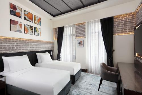 伊斯坦布尔DeCamondo Galata, a Tribute Portfolio Hotel的酒店客房配有两张床和一张书桌