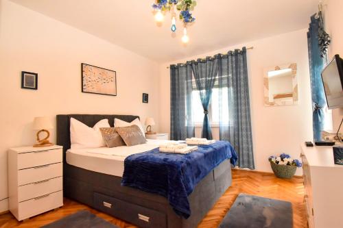 苏佩塔斯卡德拉加Villa Kristina Rab的一间卧室配有一张带蓝色毯子的床