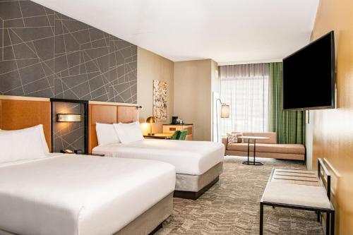 巴尔的摩SpringHill Suites by Marriott Baltimore Downtown Convention Center Area的酒店客房,设有两张床和一张沙发