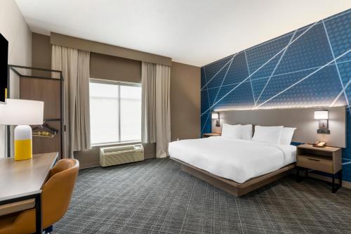 汉普顿Comfort Inn & Suites Hampton near Coliseum的酒店客房设有一张大床和一张书桌。
