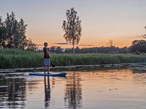 SmaltāniKrastmslas的男孩站在水中的桨板上