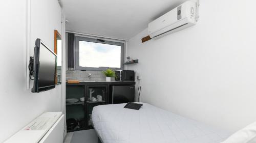 雅典Monastiraki City Sleepbox- Unspoiled Athens Apartments的小房间设有床和窗户