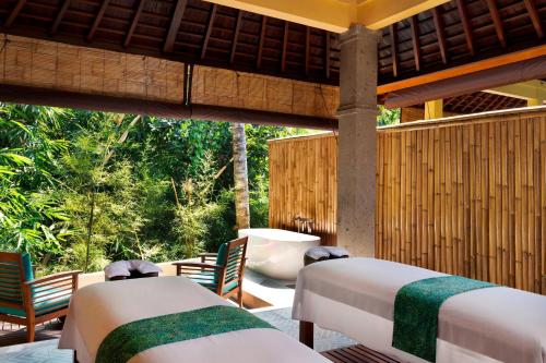乌布Element Bali Ubud的庭院内的房间,配有两张床和椅子
