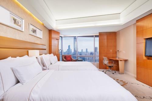 南京南京金茂威斯汀大酒店的酒店客房设有两张床和电视。