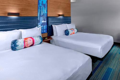 罗利布莱尔克里克雅乐轩罗利达勒姆机场酒店的配有2张床铺的酒店客房,提供白色床单和枕头