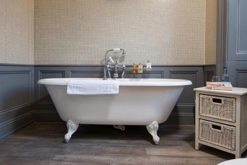 皮布尔斯格灵雷蒂别墅酒店的浴室内设有带水龙头的白色浴缸