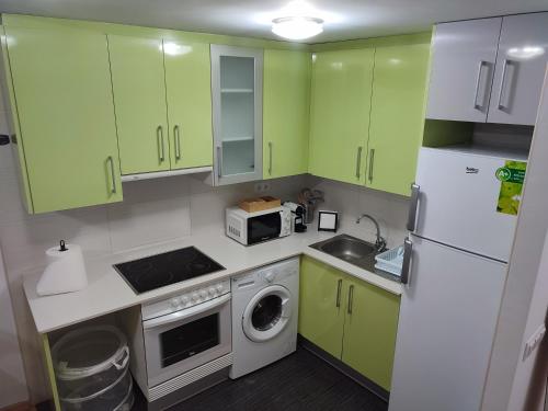 特鲁埃尔Apartamento Estrella de Teruel的厨房配有绿色橱柜和白色冰箱
