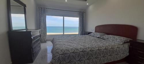 弗尼迪克Résidence Al Amine Plage accès direct à la plage的一间卧室设有一张床和一个海景窗户