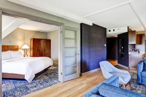 索罗尔德福朋喜来登圣凯瑟琳尼亚加拉大套房酒店的酒店客房,配有一张床和两把椅子