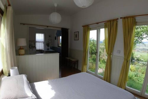 斯莱戈Innisfreedom cabin的一间卧室设有一张床和一个大窗户
