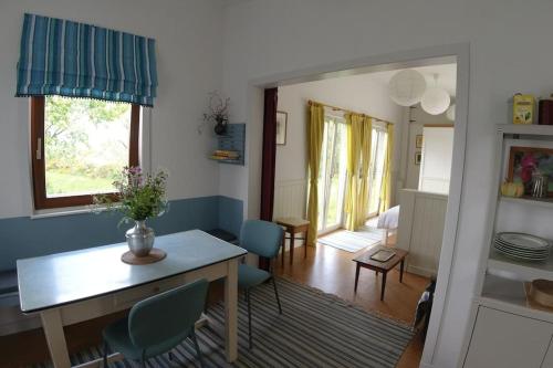 斯莱戈Innisfreedom cabin的客厅配有桌子和蓝色椅子