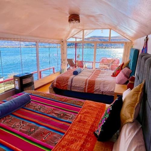 普诺Uros TITICACA home lodge的一间带两张床的卧室,享有海景